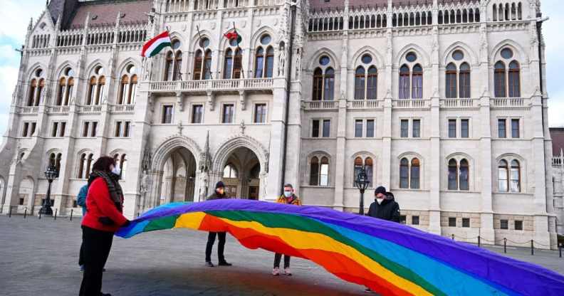 LGBT+ activists hold a 30 metre Pride flag in front of the Hungarian parliament building
