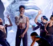 Lil Nas X in a mesh crop top surrounded by dancers