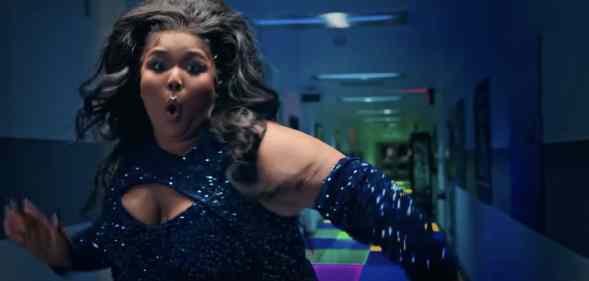 Lizzo in sequins, dancing in front of a hallway with a light-up floor