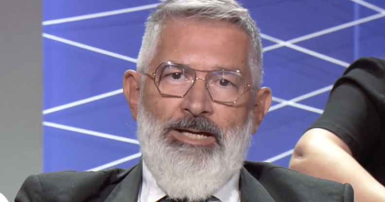 Paolo Rondelli, a white man with grey hair and a grey beard, wearing square metal glasses