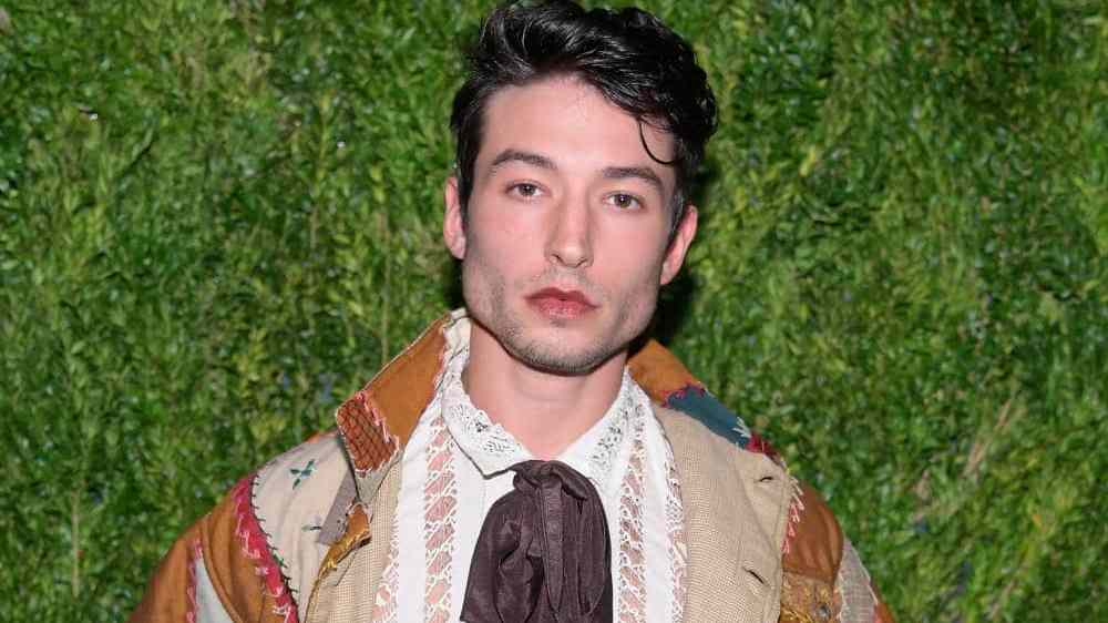 Actor Ezra Miller stares at the camera while wearing neutral coloured clothing