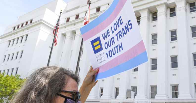 A protester props up a sign that says: 'We love our trans youth'