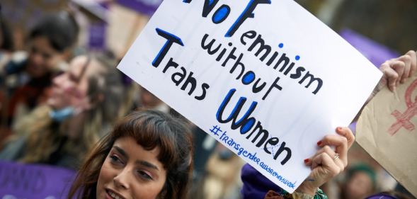 A protester holds a sign that reads: 'No feminism without trans women'