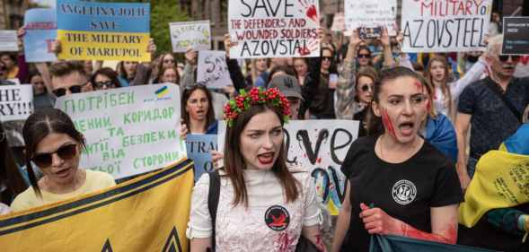People hold banners and shout slogans during a demonstration in support of Mariupol defenders on May 3.