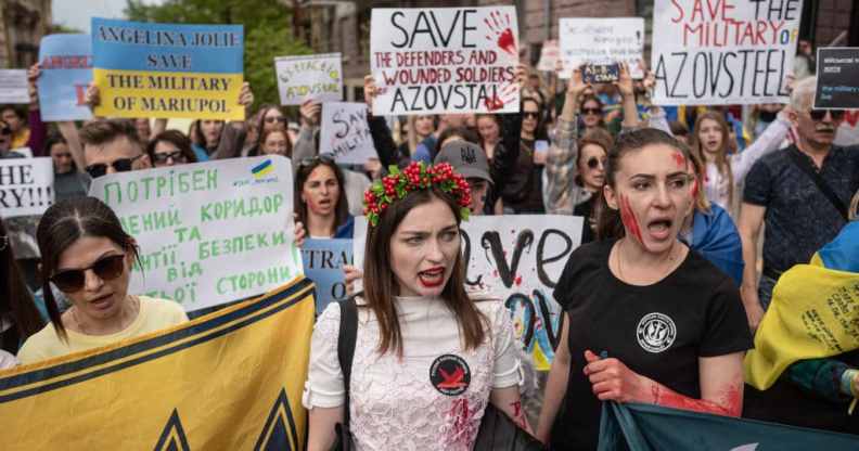 People hold banners and shout slogans during a demonstration in support of Mariupol defenders on May 3.