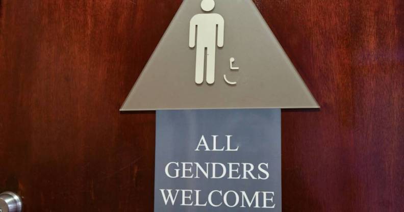 A bathroom sign with a smaller sign that reads "All genders welcome"