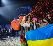 Ukraine's Kalush Orchestra hold the Eurovision trophy and a Ukraine flag