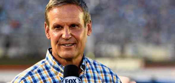 Tennessee governor Bill Lee speaks into a microphone during a sporting event
