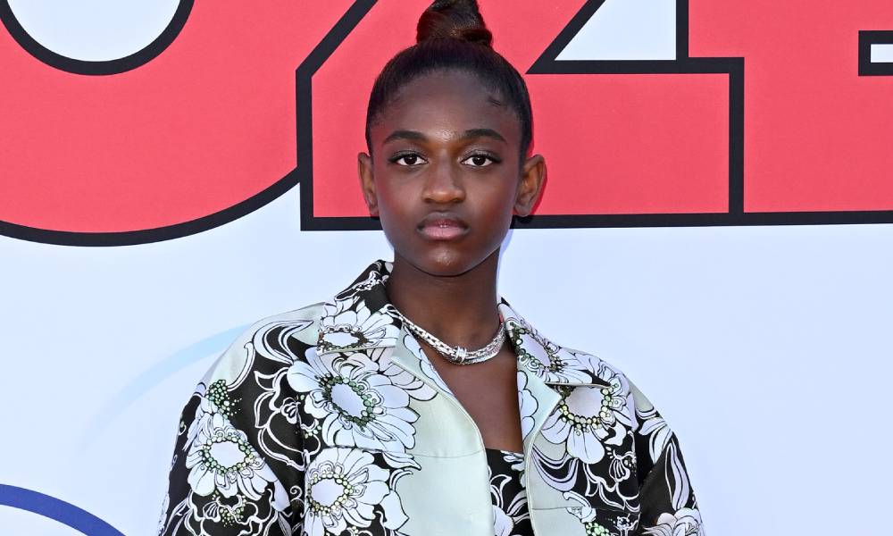 Zaya Wade stares at the camera while wearing a black and white floral patterned outfit
