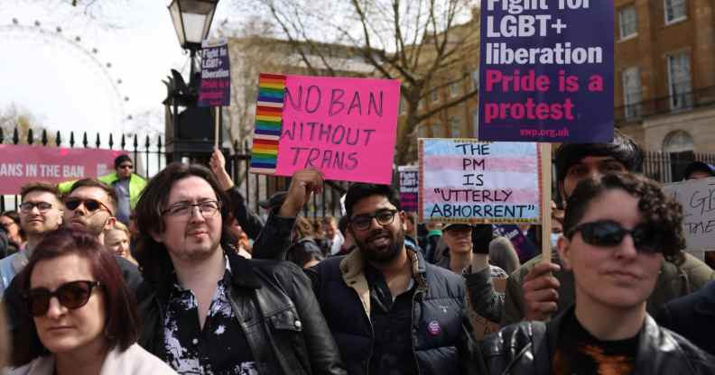 Demonstrators hold placards during the No Ban Without Trans protest