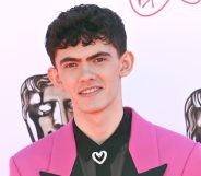 Actor Joe Locke wearing a pink suit jacket over a black shirt poses for a photo at the 2022 Virgin Media British Academy Television Awards