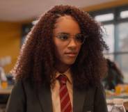 Yasmin Finney plays young teen Elle in Heartstopper. In this picture, the character is wearing a British school uniform with a dark jacket, white shirt and red striped tie