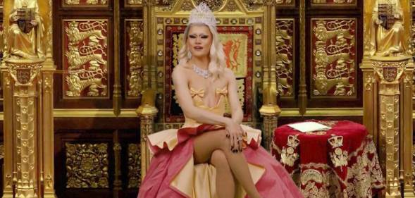 Drag Race UK queen River Medway appears wearing a peach and red coloured gown with a crown on her head while sitting on a gold throne