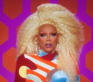 Iconic Drag Race host RuPaul wears a bright blonde wig, red white blue and yellow jumpsuit as she judges All Stars 7