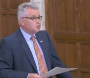 Tory MP Tim Loughton wears a blue shirt, orange tie and dark blue suit jacket during a parliament debate on non-binary legal recognition