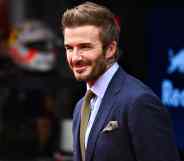 David Beckham wearing a suit, smiling
