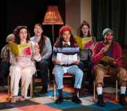 The cast of The Ministry of Lesbian Affairs sitting on chairs, holding songbooks and singing