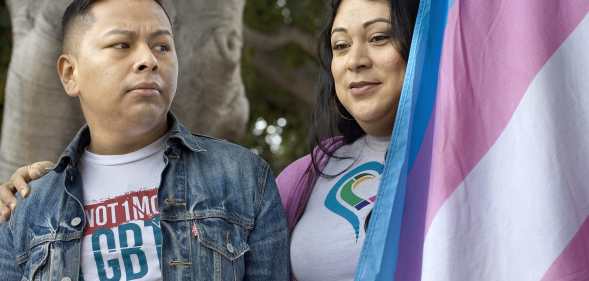 Jennicet Gutiérrez drapes herself with a trans Pride flag