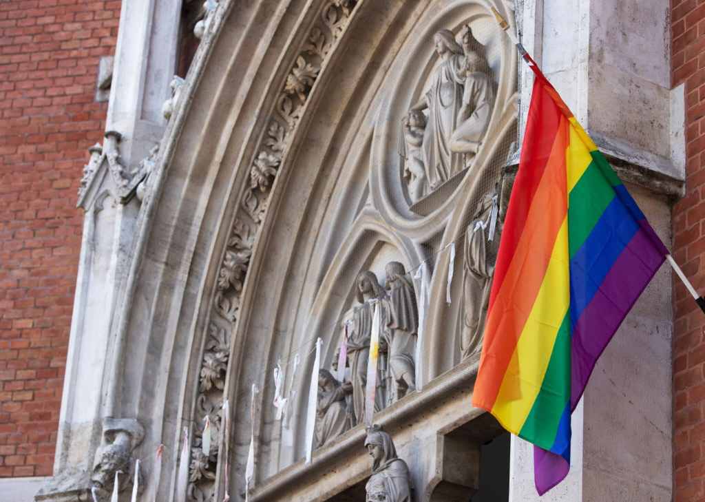 Pride flag flying from church building