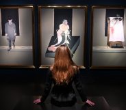A woman looks at three artworks by Francis Bacon in a gallery
