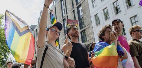 People walk through Oslo holding Pride flags