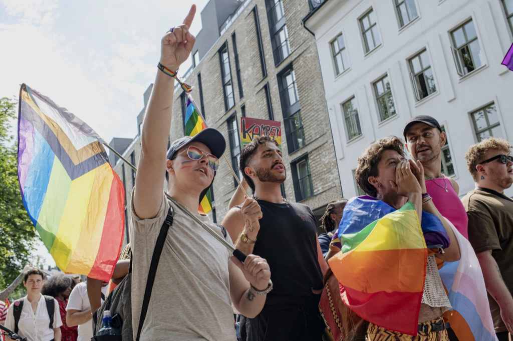 People walk through Oslo holding Pride flags