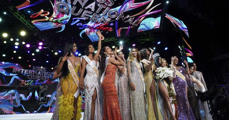 Contestants stand over the Miss International Queen 2022 Transgender Beauty Contest sign on stage