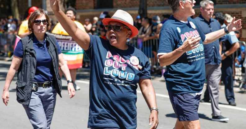 Black Chicago mayor, Lori Lightfoot, waving to Pride crowds in Chicago, with wife, Amy Eshleman, by her side.