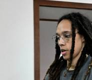 Brittney Griner wears a grey shirt and has her hair in locks as she walks to a preliminary court hearing in Russia