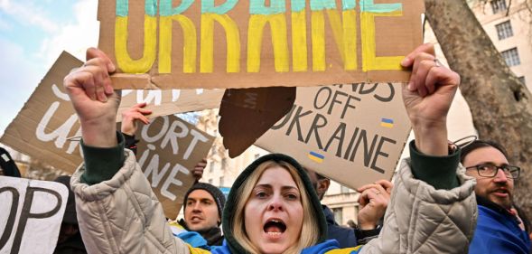 A Ukrainian person holds a sign reading "Ukraine" at a protest outside Downing Street against the recent invasion of Ukraine on February 24, 2022 in London, England.