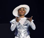 Ariana DeBose wears a white hat, white outfit and silver sequinned top as she sings on stage during the 2022 Tony Awards