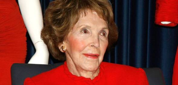 Former first lady Nancy Reagan wears read as she stares off camera at someone else