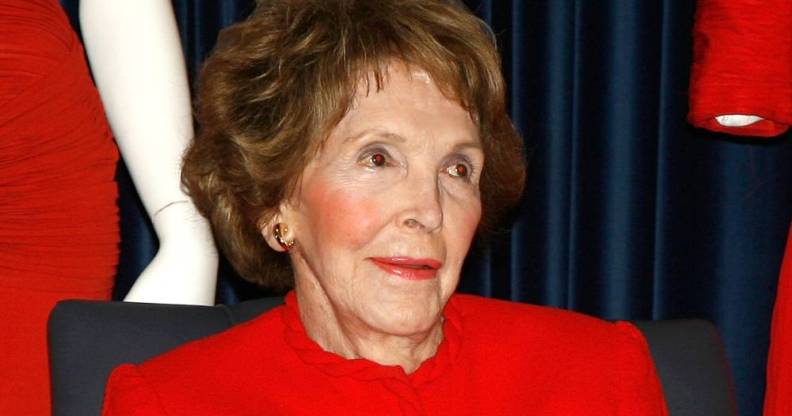 Former first lady Nancy Reagan wears read as she stares off camera at someone else
