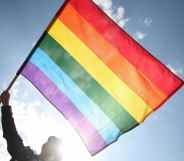 A person waving a Pride flag.
