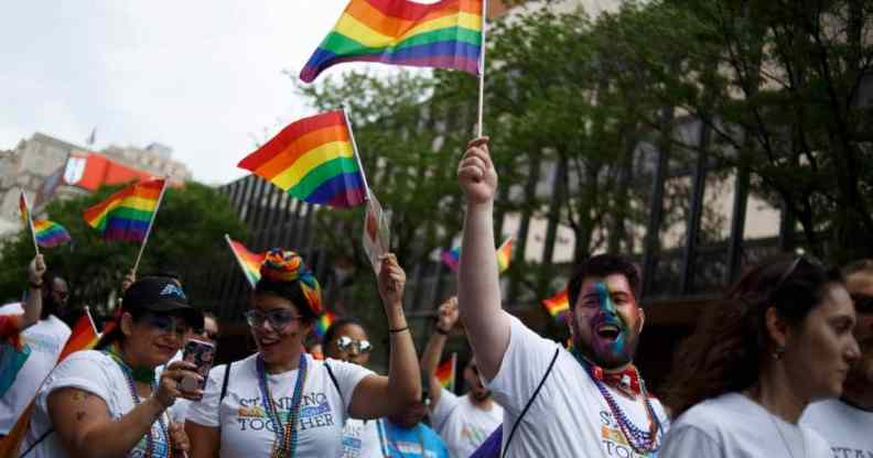 Revelers hold up LGBTQ+ Pride flags as they participate in the Philadelphia LGBT Pride Parade through the city's "Gayborhood" and downtown historic district in Pennsylvania