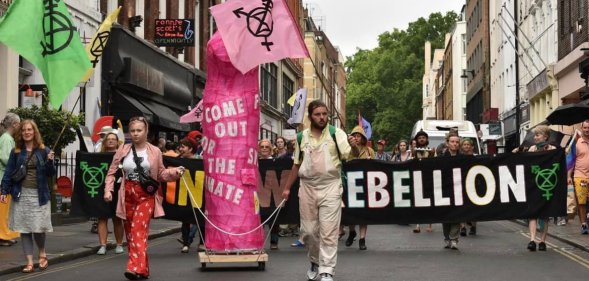 Rainbow Rebellion members march in Soho with a giant pink dildo