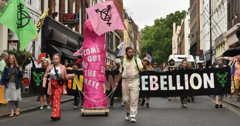 Rainbow Rebellion members march in Soho with a giant pink dildo