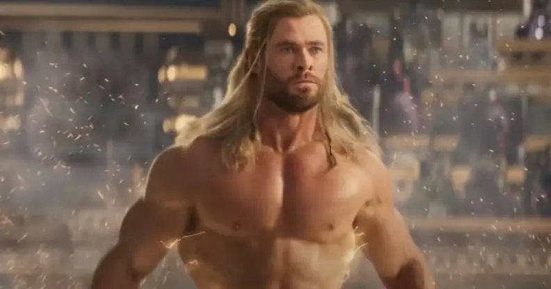 Chris Hemsworth, who plays Thor in the Marvel film Thor: Love and Thunder, stands naked in front of a crowd as lightning races down his body