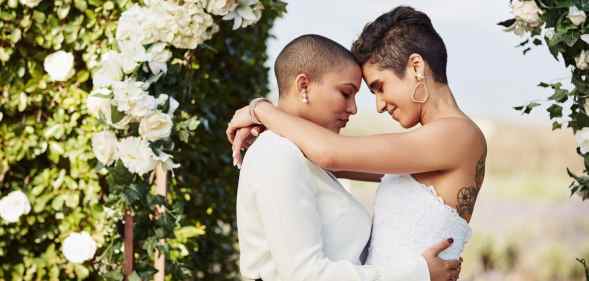 Cropped shot of an affectionate young lesbian couple sharing an intimate moment with their arms around each other on their wedding day
