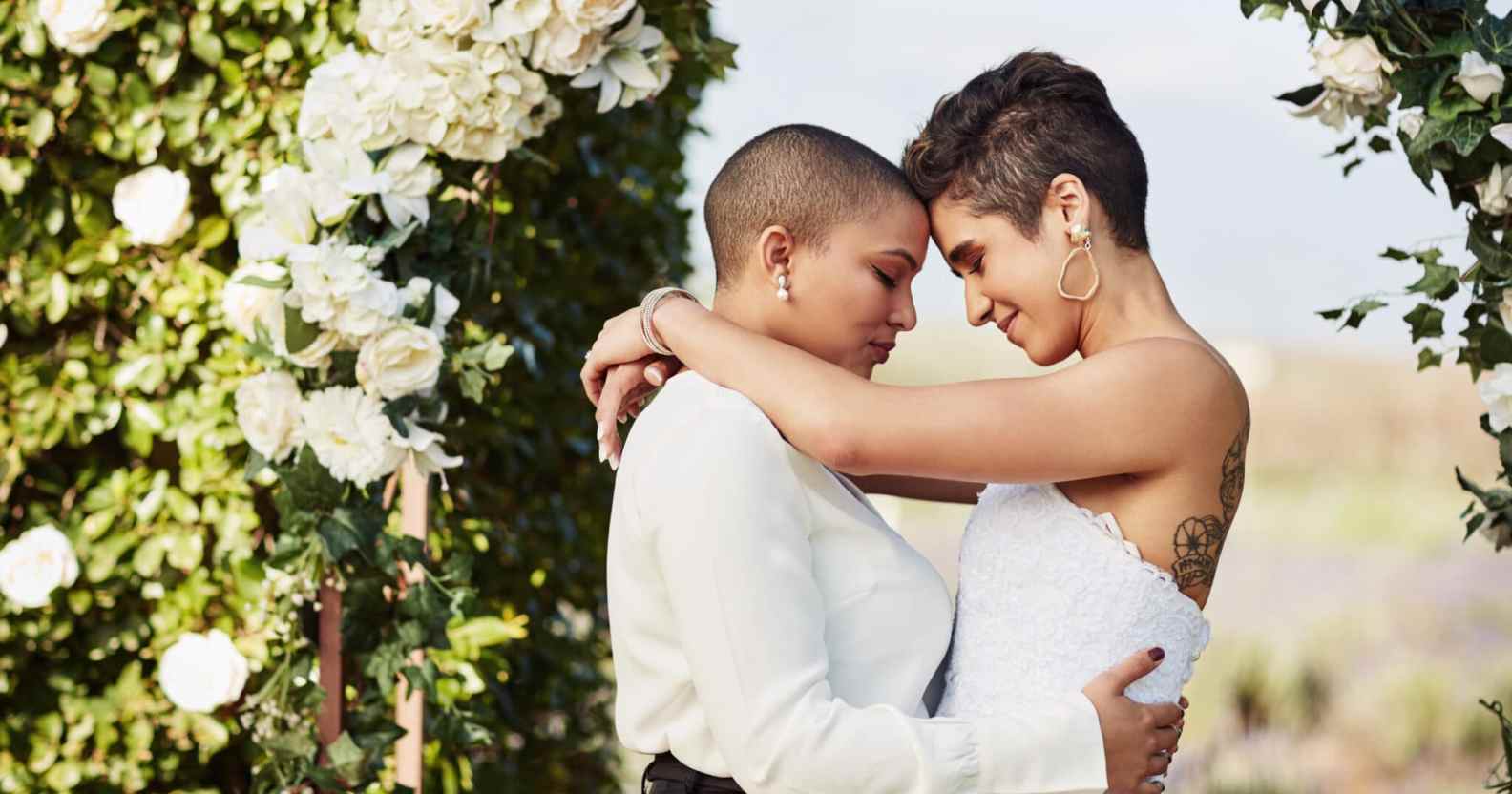 Cropped shot of an affectionate young lesbian couple sharing an intimate moment with their arms around each other on their wedding day