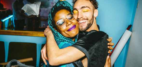 Happy friends hugging each other in living room