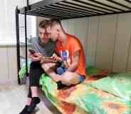 Two men sitting on a bunk bed in an LGBTQ+ shelter in Ukraine.