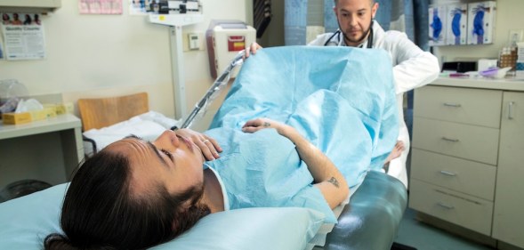 A trans person receives a pelvic exam by healthcare professional