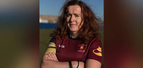 Alix Fitzgerald is seen wearing a red rugby jersey as she crosses her arms in front of her chest