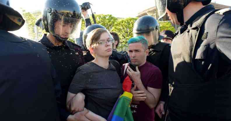 Russian riot police detained gay rights activists holding a LGBTQ+ rainbow flag