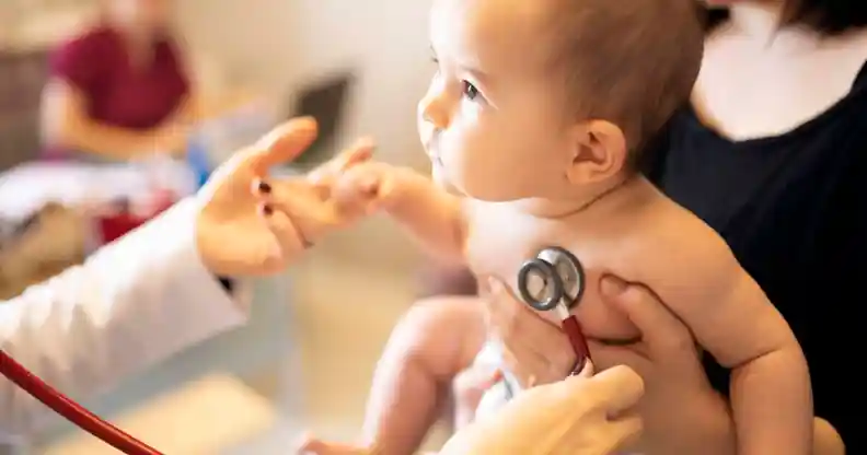 A doctor places a stethoscope on a baby
