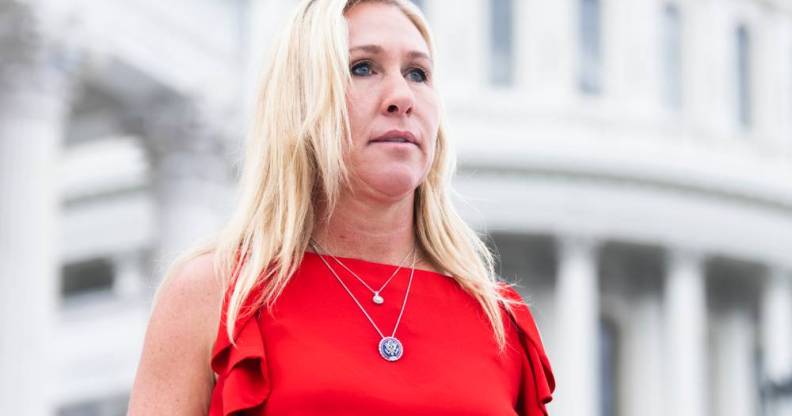 Marjorie Taylor Greene wears a red sleeveless top with little ruffles and two silver necklaces as she stands House steps of the US Capitol