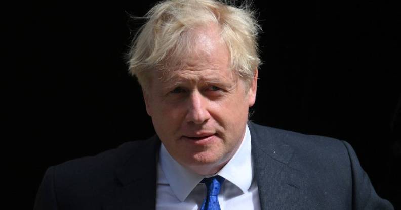 Prime minister Boris Johnson wears a white button up shirt, blue tie and grey-blue suit jacket