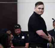Leader of white supremacist group NSC-131 Chris Hood smiles at the camera while in court