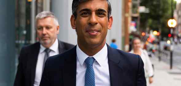 Rishi Sunak walks towards the camera in a suit